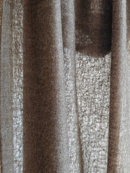 Close up of a natural brown cashmere shawl featuring a soft brushed texture, rich fiber detail, and warm earthy tones. The draped cashmere fabric highlights the quality, thickness, and artisanal character of this premium wrap.