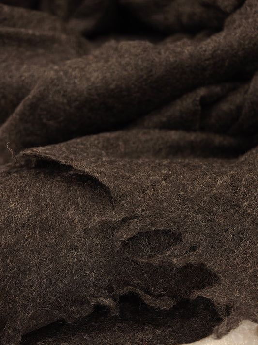 Close up of delicate fringe edges and natural cashmere fibers, showcasing artisanal craftsmanship and premium texture.
