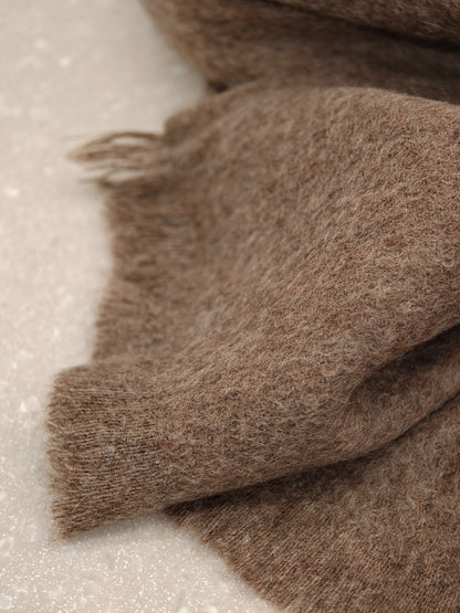Soft close up of the edge and texture of a brown pure cashmere brushed scarf. Highlights the featherlight feel, clean finish, and fine brushed fibers of Duo Plus premium cashmere.