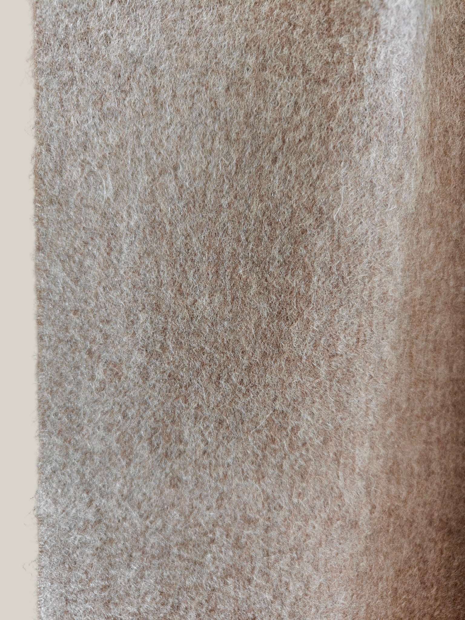 Detailed view of the brushed fabric texture of a pure cashmere scarf in taupe. Shows the fine loft, soft fibers, and subtle natural undertones characteristic of Duo Plus luxury cashmere.