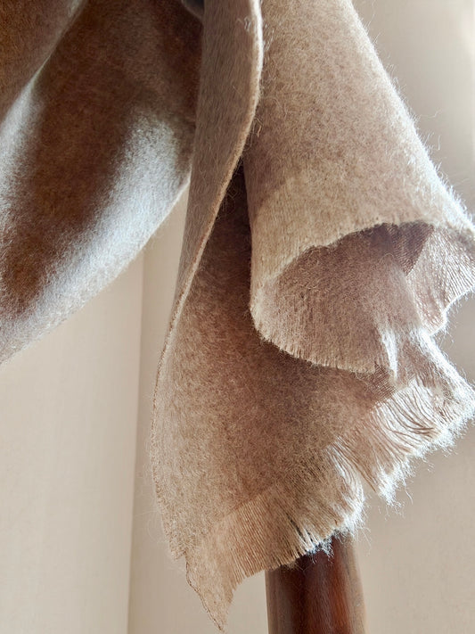 Close up of a natural taupe pure cashmere brushed scarf from Duo Plus, showing its airy texture and softly fringed edges. Highlights the warm neutral tone and fine Inner Mongolian cashmere fibers.