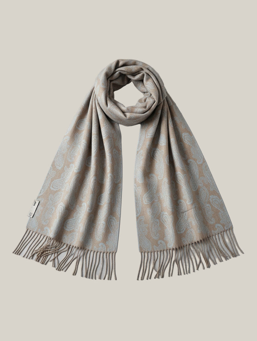 Studio product shot of a pure cashmere paisley scarf in beige and blue with long draped panels and fringe edges. Luxurious winter accessory crafted from fine Inner Mongolian cashmere.