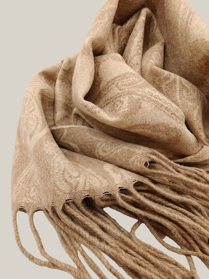 Close up of a pure cashmere paisley scarf from Duo Plus in soft taupe beige. Shows the detailed woven paisley pattern and plush twisted fringe. Highlights the lightweight texture of Inner Mongolian cashmere.