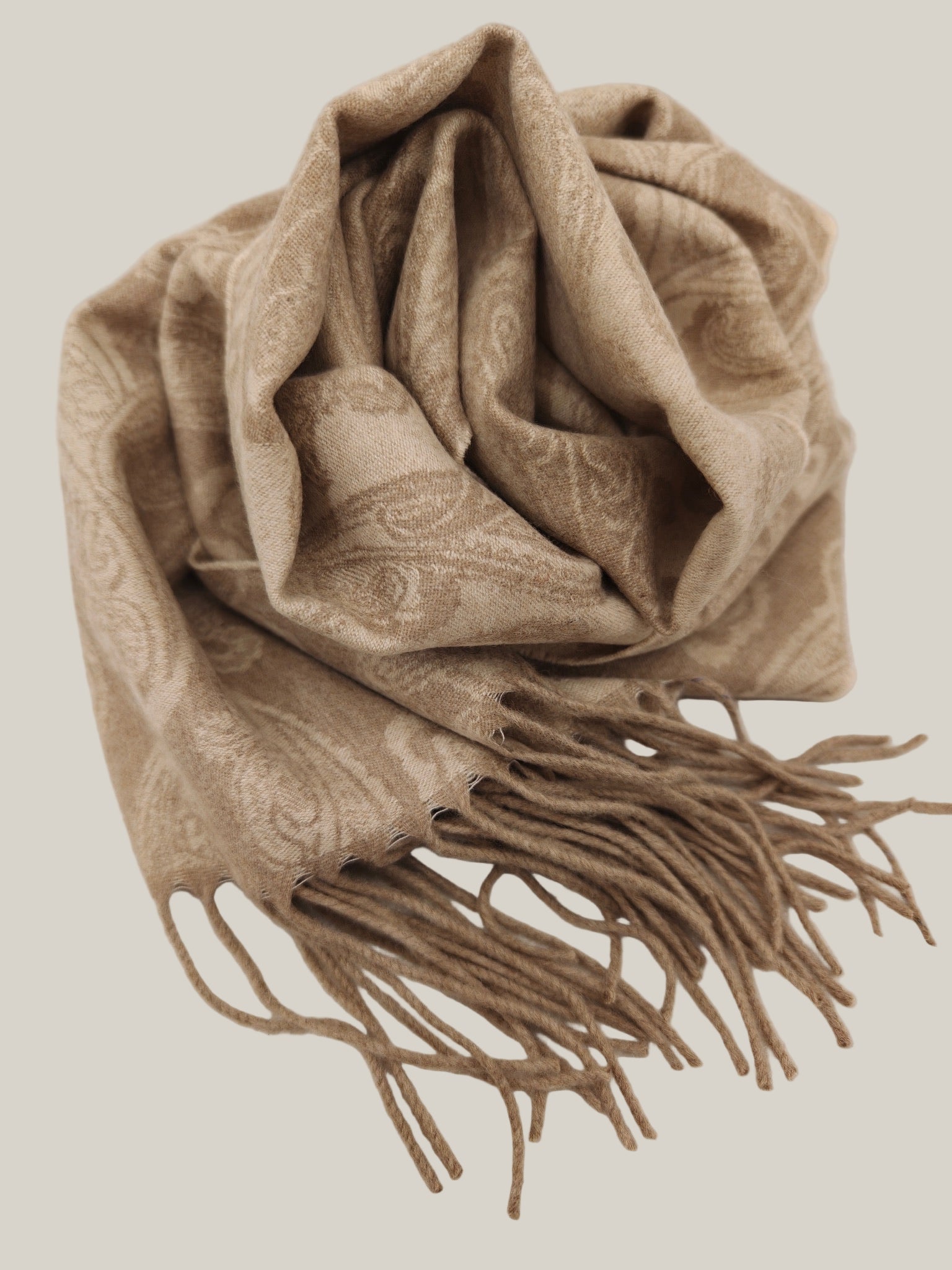 Pure cashmere paisley scarf folded in a relaxed drape, featuring a warm taupe tone and subtle woven pattern. Shows the smooth hand feel and natural softness of premium cashmere from Duo Plus.