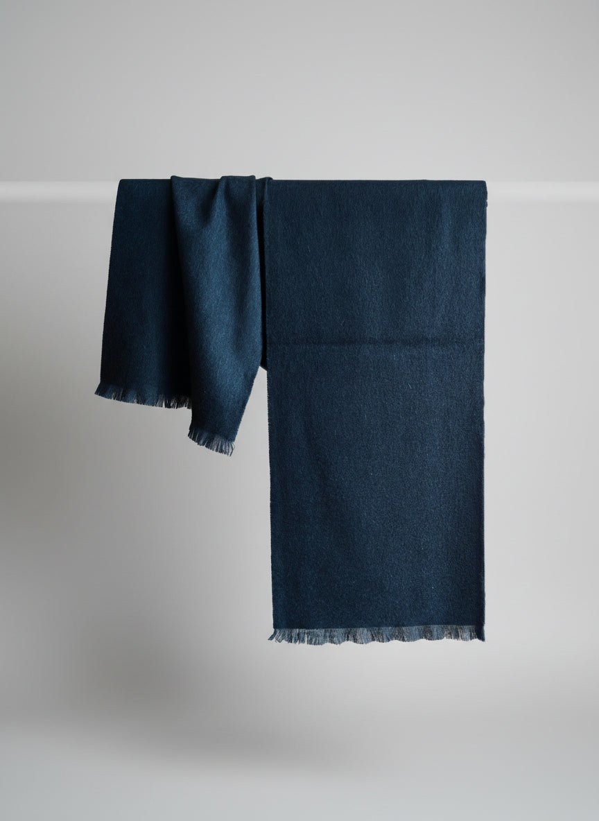 Deep navy pure cashmere scarf displayed hanging to show its clean silhouette and soft drape. Features a rich blue tone and brushed texture that reflect Duo Plus luxury craftsmanship.