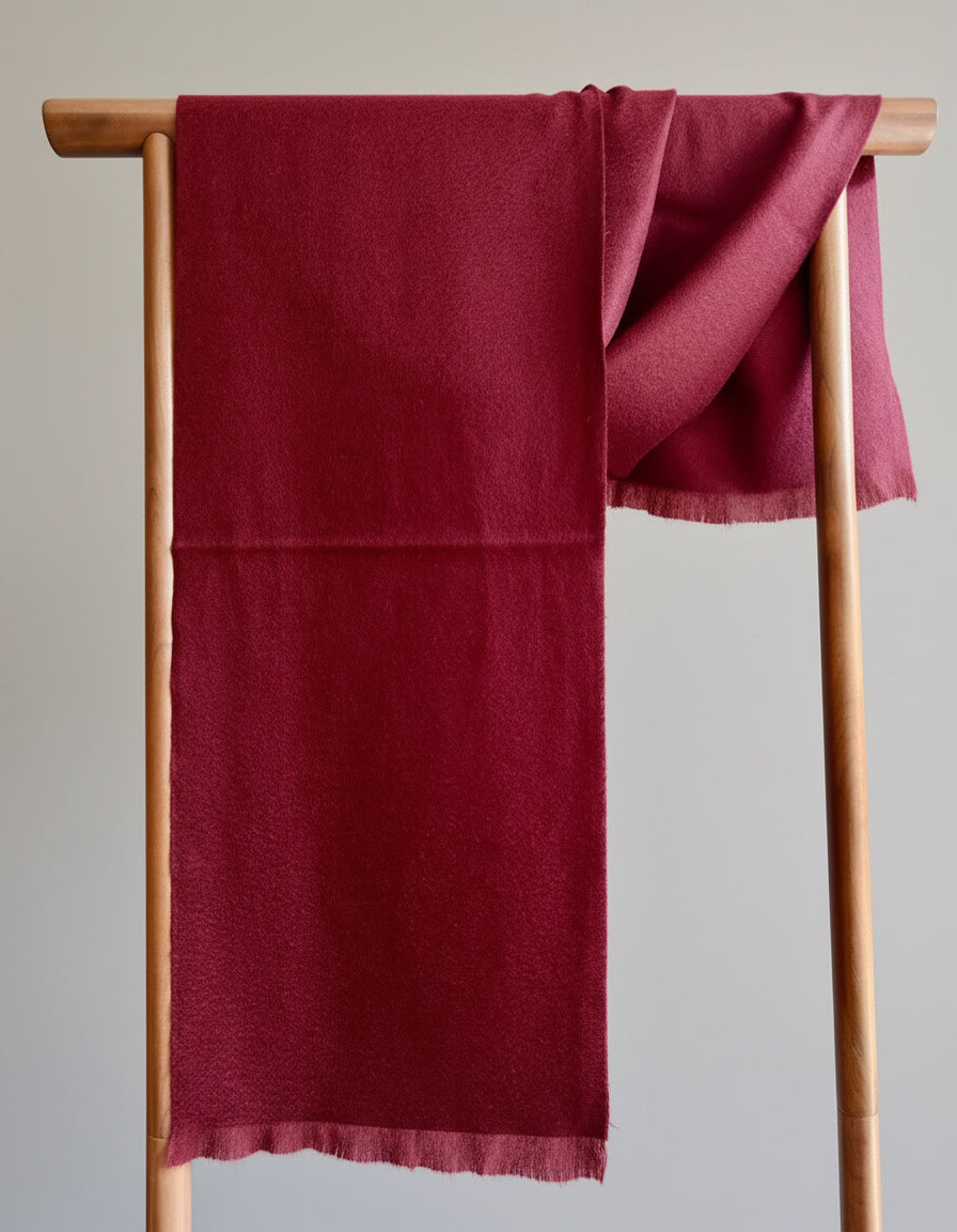 Full length view of a red pure cashmere scarf hanging on a wooden rack. Shows the saturated color, natural sheen, and soft loft of premium Duo Plus cashmere.