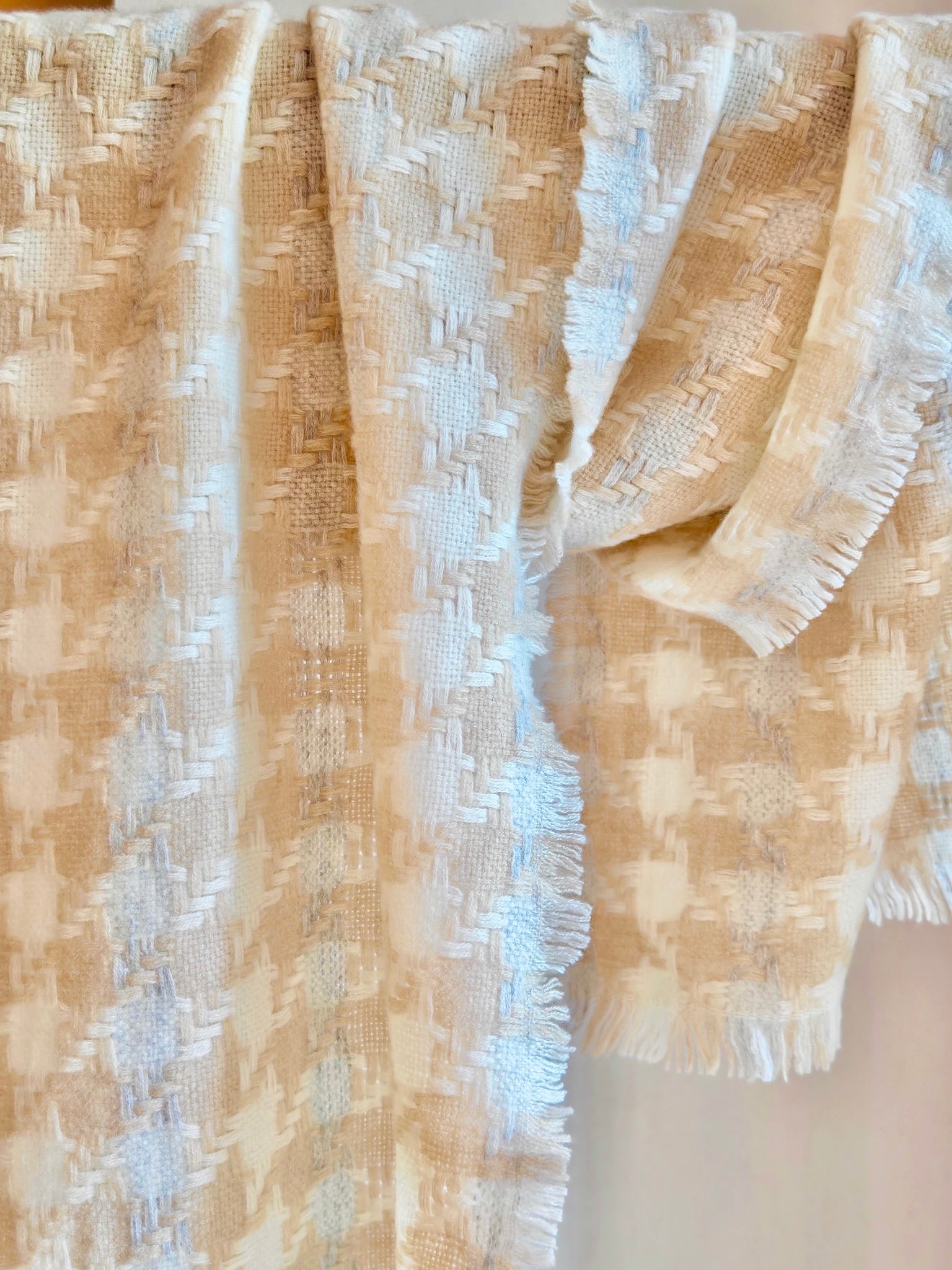 Pure cashmere textured scarf displayed hanging to show its cream and beige woven pattern. Features a soft three dimensional grid texture, light fringe edges, and the warm natural tones of Duo Plus cashmere.