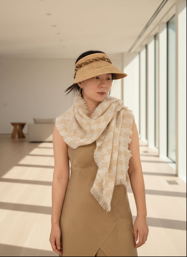 Lifestyle photo of a pure cashmere textured scarf in cream and beige draped elegantly over a model. Shows the soft woven detail, lightweight feel, and versatile styling of Duo Plus luxury cashmere.