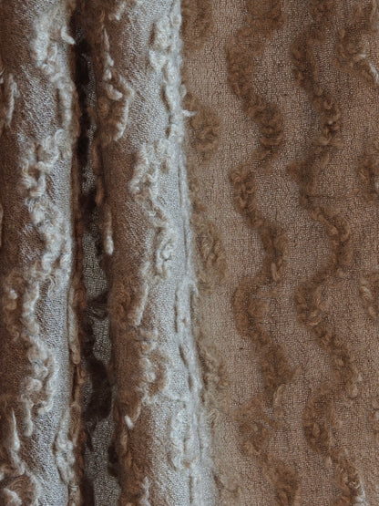 A macro close up of the Ripples Cashmere Wrap showing the intricate raised pattern and fine Inner Mongolian cashmere fibers. The image highlights the sculpted texture and quiet luxury appeal.