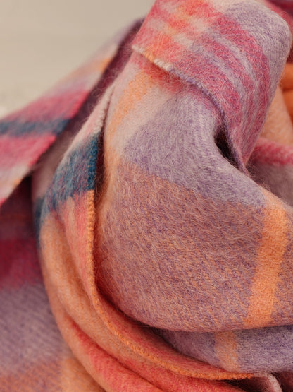 Close up of a slim pastel cashmere scarf from Duo Plus showing its soft brushed texture and plaid pattern in lavender, coral, peach, and teal. Highlights the ultra soft Inner Mongolian cashmere fibers.