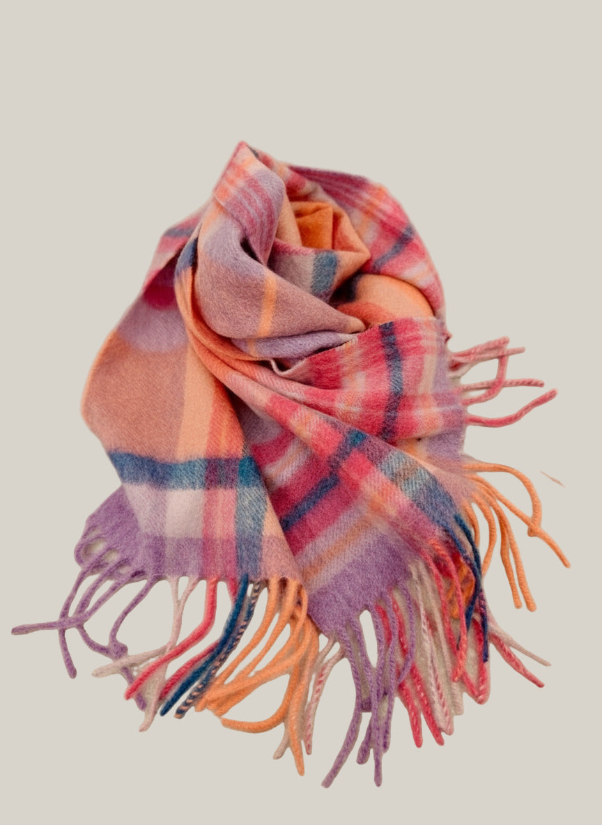 Slim pastel cashmere scarf folded to show its lightweight drape and colorful plaid pattern. Features brushed Inner Mongolian cashmere with multicolor fringes for a soft winter look.