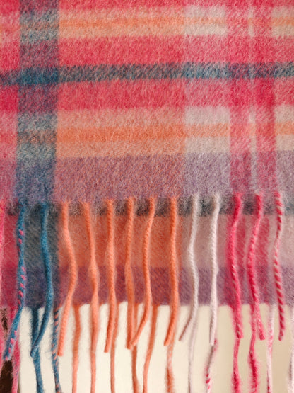 Slim pastel cashmere scarf hanging to show its full plaid pattern and colorful fringe detail. Made from brushed Inner Mongolian cashmere with a soft airy texture.